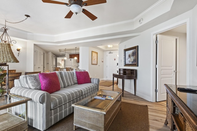 living room featuring wood-type flooring, ornamental molding, and ceiling fan