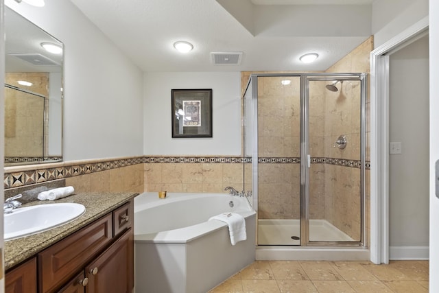 bathroom with tile patterned flooring, vanity, independent shower and bath, and a textured ceiling