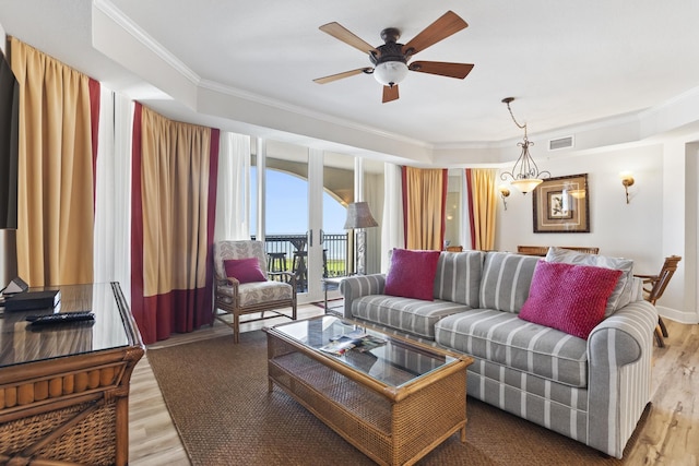 living room featuring crown molding, light hardwood / wood-style flooring, and ceiling fan