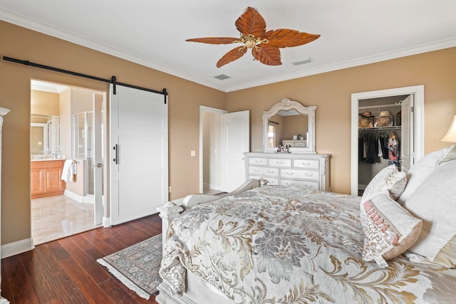 821 Kalli Creek Ln, Saint Augustine, FL 32080 - bedroom featuring a barn door, dark wood-type flooring, crown molding, a walk in closet, and a closet
