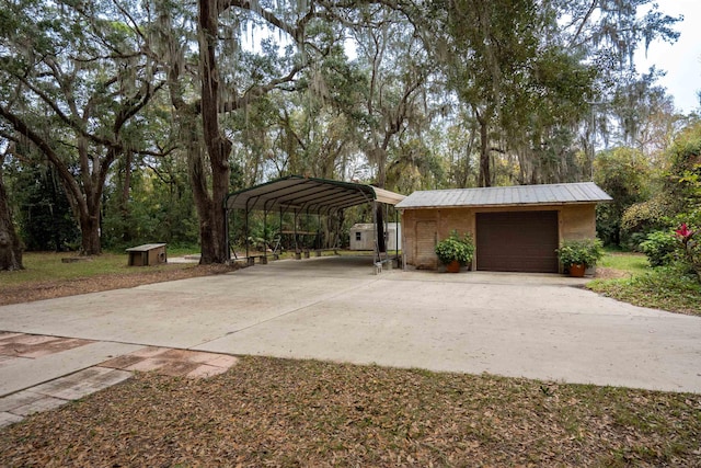 exterior space with a carport, a garage, and an outbuilding