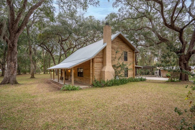 view of property exterior with a lawn and a patio