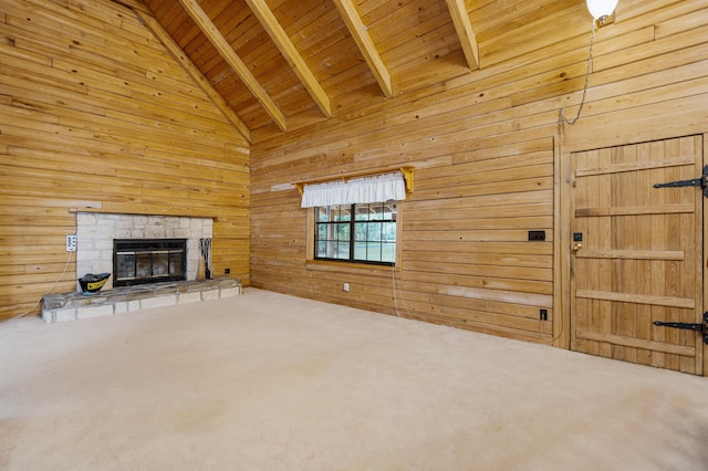 unfurnished living room with high vaulted ceiling, a stone fireplace, wooden walls, beam ceiling, and wood ceiling