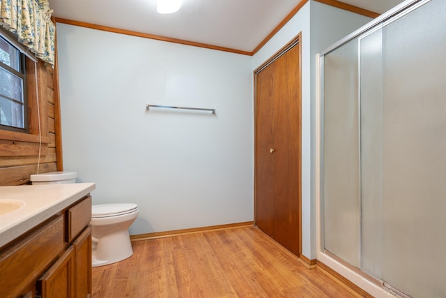 bathroom featuring vanity, hardwood / wood-style flooring, an enclosed shower, and crown molding