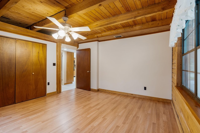 unfurnished bedroom featuring wooden ceiling, ceiling fan, beamed ceiling, light hardwood / wood-style floors, and a closet