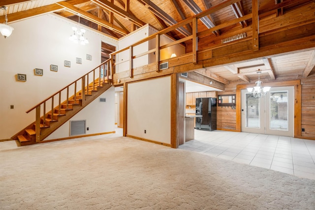 unfurnished living room featuring beam ceiling, high vaulted ceiling, a chandelier, light tile patterned floors, and wood ceiling