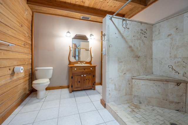 bathroom with a tile shower, wooden ceiling, tile patterned flooring, toilet, and vanity