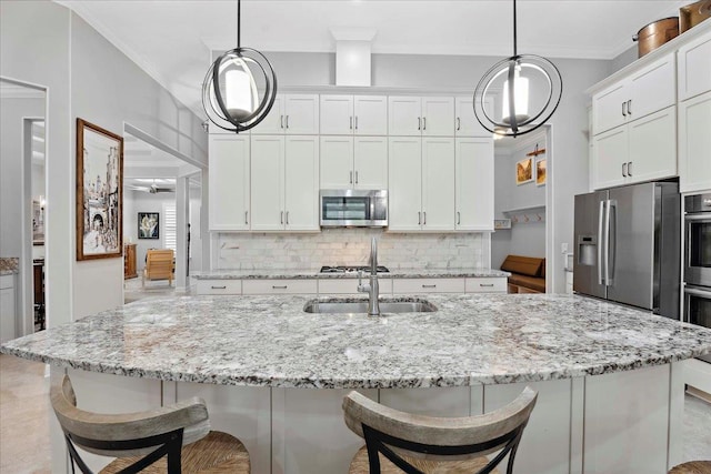 587 Pescado Dr, Saint Augustine, FL 32095 - kitchen with stainless steel appliances, decorative backsplash, white cabinetry, and ornamental molding