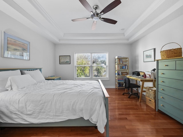 bedroom with dark wood-type flooring, ceiling fan, crown molding, and a raised ceiling