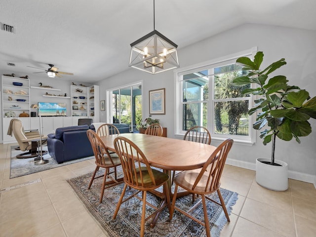 dining room with light tile patterned floors, ceiling fan with notable chandelier, and vaulted ceiling