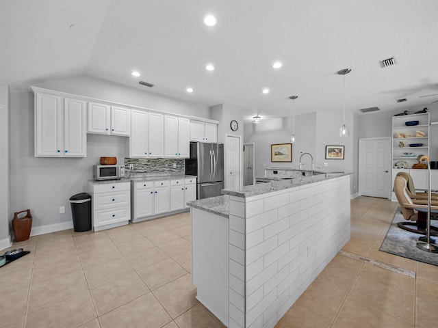 kitchen featuring light tile patterned flooring, appliances with stainless steel finishes, white cabinetry, hanging light fixtures, and light stone countertops