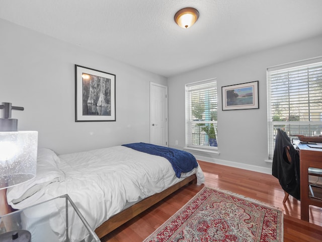 bedroom with hardwood / wood-style floors and a textured ceiling