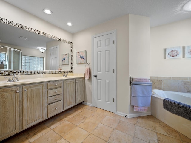 bathroom with tasteful backsplash, vanity, and shower with separate bathtub