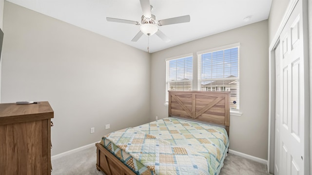 carpeted bedroom featuring ceiling fan and a closet