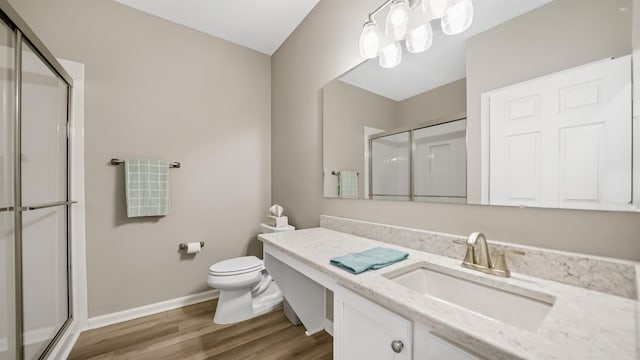 bathroom featuring toilet, a shower with door, vanity, and hardwood / wood-style flooring