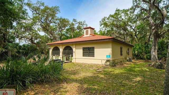 rear view of house featuring a yard and central AC unit