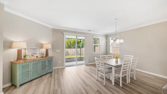 dining room featuring crown molding, light hardwood / wood-style flooring, and a chandelier