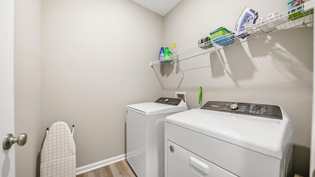 laundry area featuring separate washer and dryer and light hardwood / wood-style floors