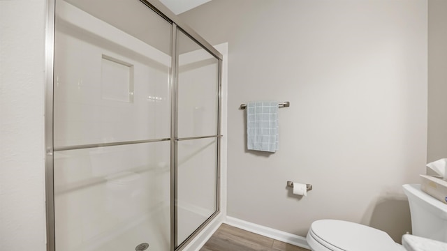 bathroom with a shower with door, wood-type flooring, and toilet