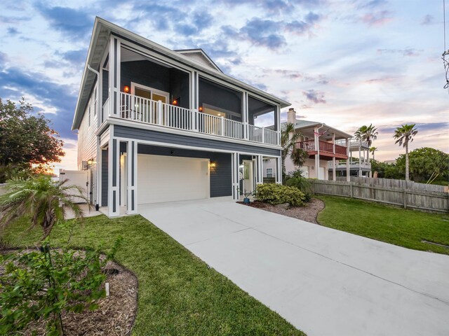 5813 Rudolph Ave, Saint Augustine, FL 32080 - view of front of house with a balcony, fence, an attached garage, driveway, and a yard