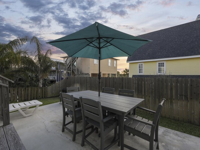 5813 Rudolph Ave, Saint Augustine, FL 32080 - patio terrace at dusk with a fenced backyard and outdoor dining area