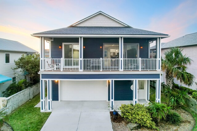 5813 Rudolph Ave, Saint Augustine, FL 32080 - raised beach house with concrete driveway, a garage, fence, and a shingled roof