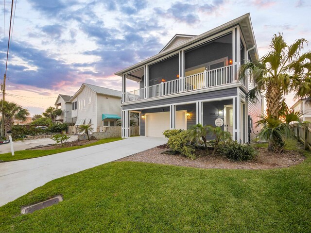 5813 Rudolph Ave, Saint Augustine, FL 32080 - view of front of house featuring a balcony, concrete driveway, an attached garage, and a front lawn
