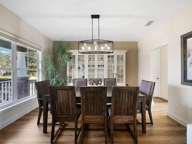 dining space featuring hardwood / wood-style floors and a notable chandelier