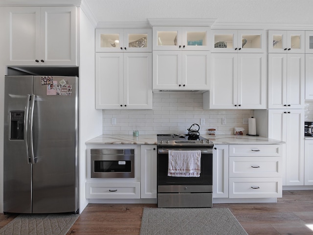 kitchen featuring hardwood / wood-style flooring, light stone countertops, appliances with stainless steel finishes, and white cabinets