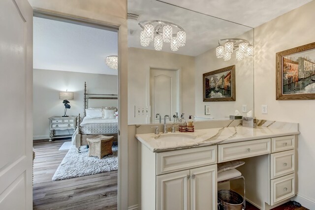 bathroom with vanity, hardwood / wood-style floors, toilet, and an inviting chandelier