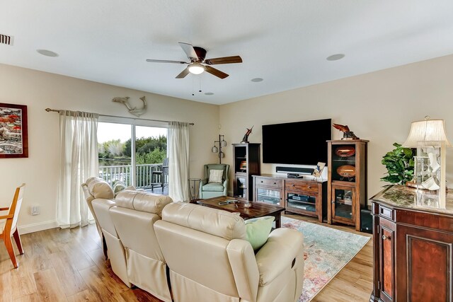 living room featuring wood-type flooring and ceiling fan