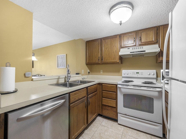 kitchen with sink, kitchen peninsula, a textured ceiling, white appliances, and light tile patterned floors