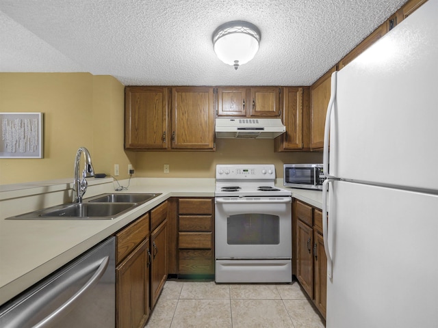 kitchen with a textured ceiling, light tile patterned flooring, sink, and stainless steel appliances