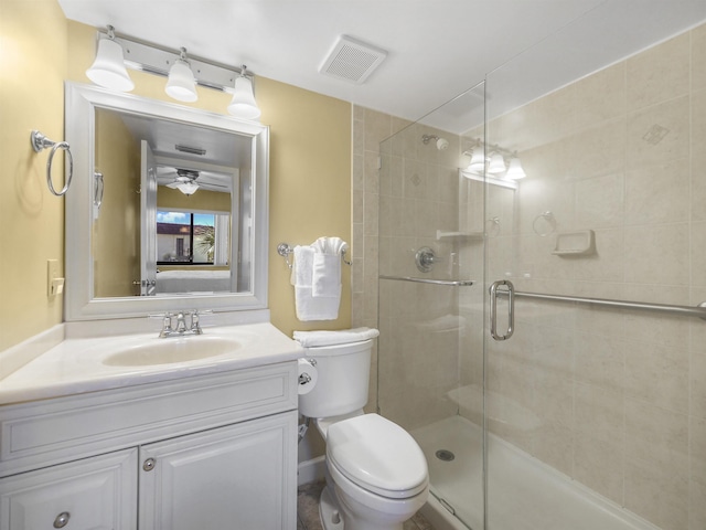 bathroom featuring vanity, ceiling fan, toilet, and a shower with door