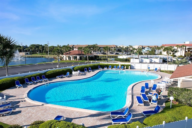 view of pool with a patio and a water view