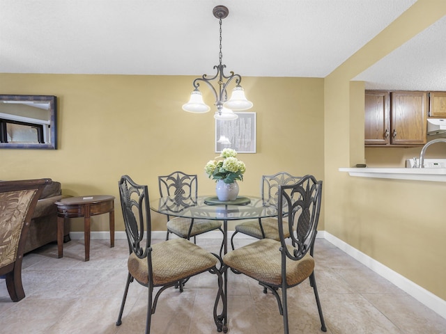 tiled dining room featuring a chandelier and sink