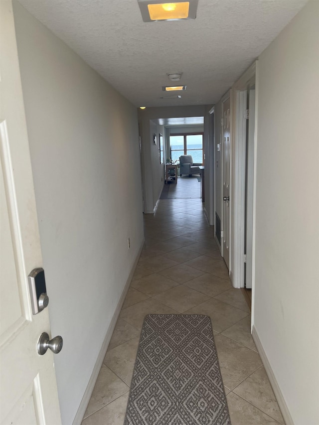8050 A1A S Unit 205, Saint Augustine, FL 32080 - corridor with a textured ceiling, light tile patterned flooring, and baseboards