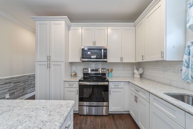 kitchen with decorative backsplash, dark hardwood / wood-style flooring, white cabinetry, and appliances with stainless steel finishes