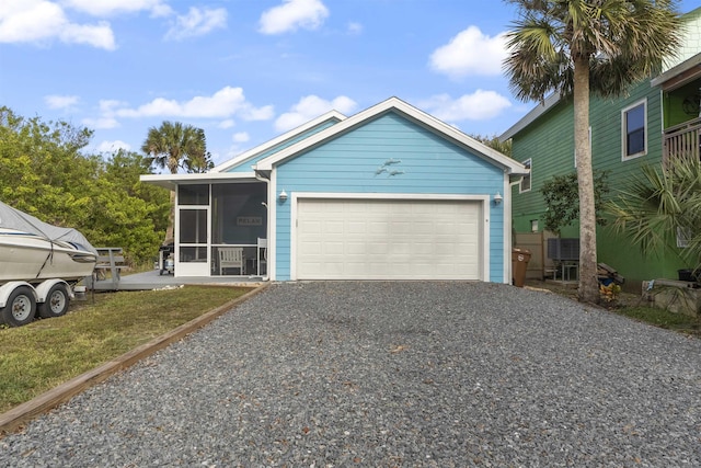 view of front of home with a sunroom, a garage, and a front yard