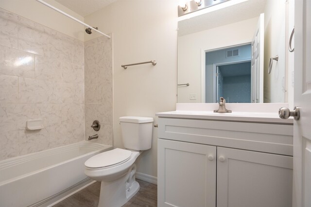 full bathroom with vanity, wood-type flooring, tiled shower / bath combo, and toilet