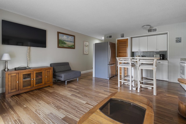 living room featuring light hardwood / wood-style flooring and a textured ceiling