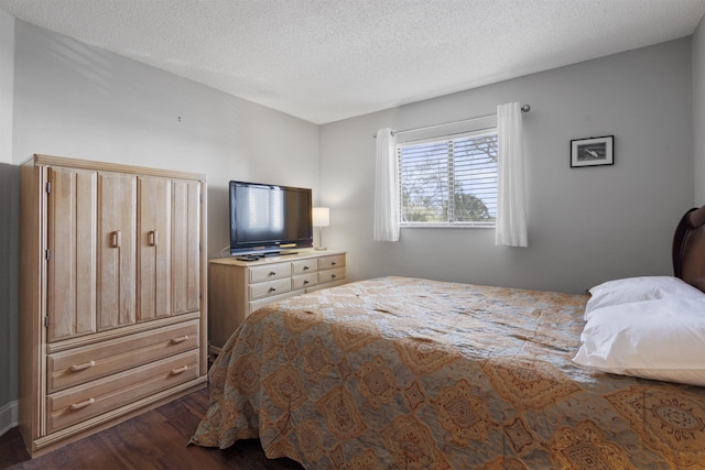 bedroom with dark hardwood / wood-style floors and a textured ceiling