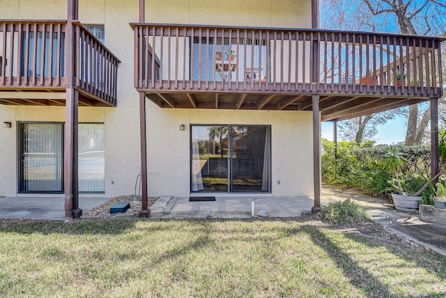 back of property featuring a yard and a wooden deck