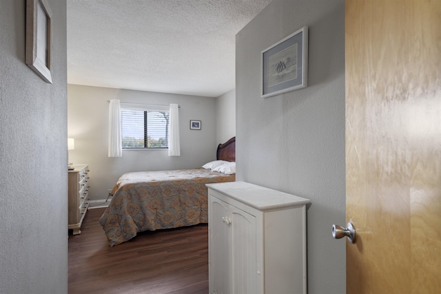 bedroom with dark wood-type flooring and a textured ceiling