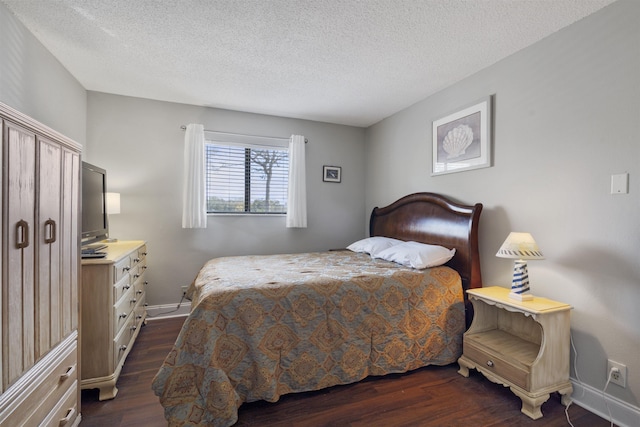 bedroom with a textured ceiling and dark wood-type flooring