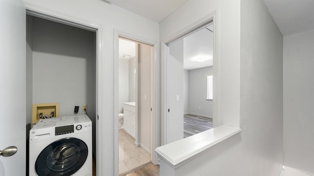 laundry room with washer / dryer and light wood-type flooring