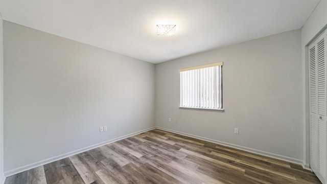 unfurnished bedroom featuring dark wood-type flooring and a closet