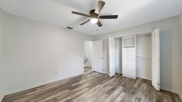 unfurnished bedroom featuring hardwood / wood-style floors, a closet, and ceiling fan