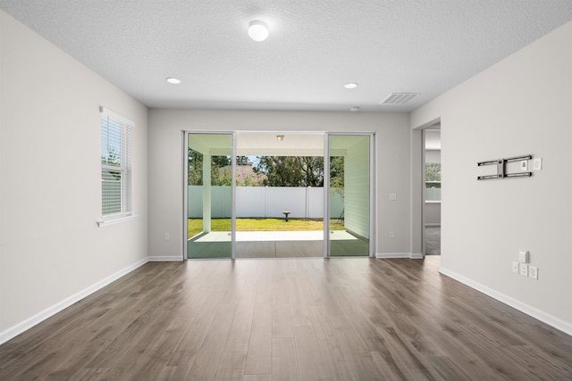 638 Honeycomb Trl, Saint Augustine, FL 32095 - unfurnished room with dark wood finished floors, a textured ceiling, baseboards, and visible vents
