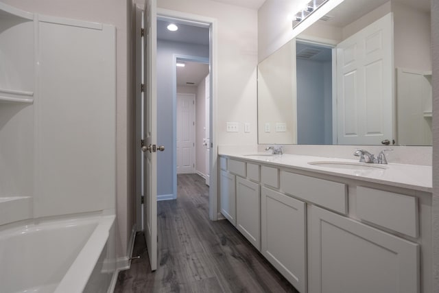 638 Honeycomb Trl, Saint Augustine, FL 32095 - bathroom featuring a tub, a sink, double vanity, and wood finished floors